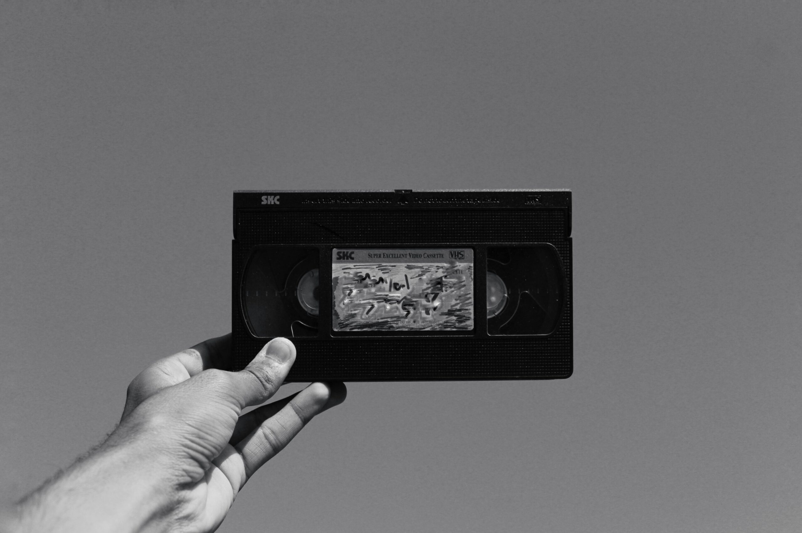 VHS kazeta držená v ruce, symbolizující proces digitalizace